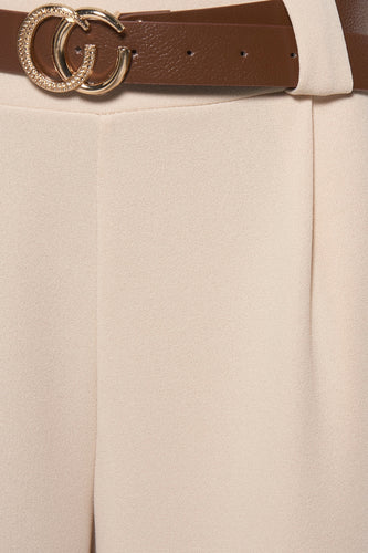Beige pantalon met bruine riem en gouden gesp.