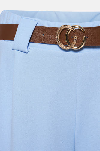 Pantalon bleu de Terra di Siena avec une ceinture brune et une boucle dorée.