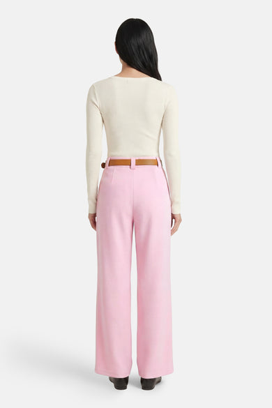 Pantalon rose de Terra di Siena, à jambes larges, combiné avec un haut écru et une ceinture marron, vu de dos.