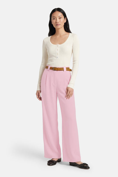 Pantalon rose de Terra di Siena, combiné avec une ceinture marron et des chaussures noires.