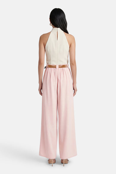 Pantalon de costume rose de Terra di Siena, avec une ceinture marron, des jambes larges et des talons nude.