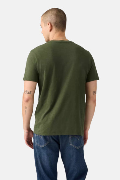 T-shirt vert de manteses courtes Levi's, vu vu de derrière, associé à un jean bleu.