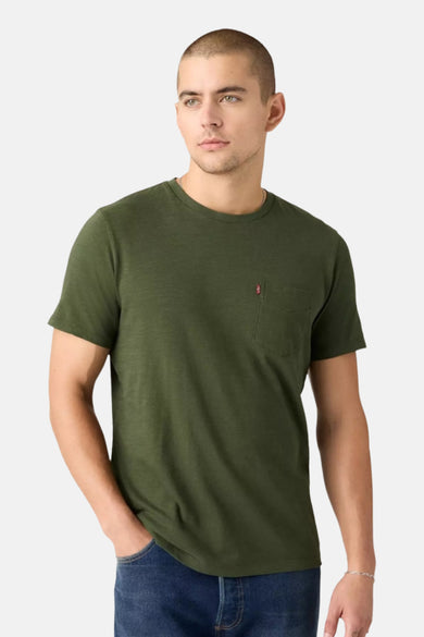 T-shirt vert de manches courtes de Levi's, avec une poche poitrine et porté port un jeans.