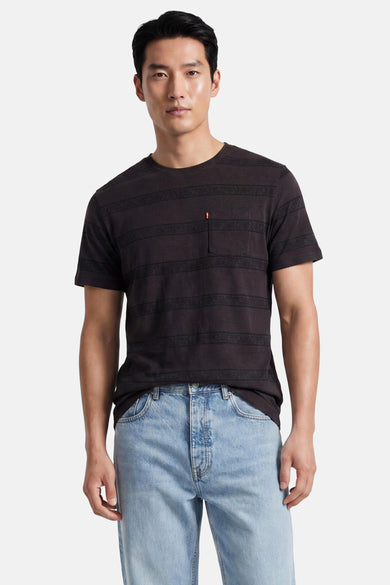 Zwart T-shirt met korte mouwen van Levi's®, met donkere strepen met paisley-motief en een borstzakje, gedragen door een man op een lichte jeans.