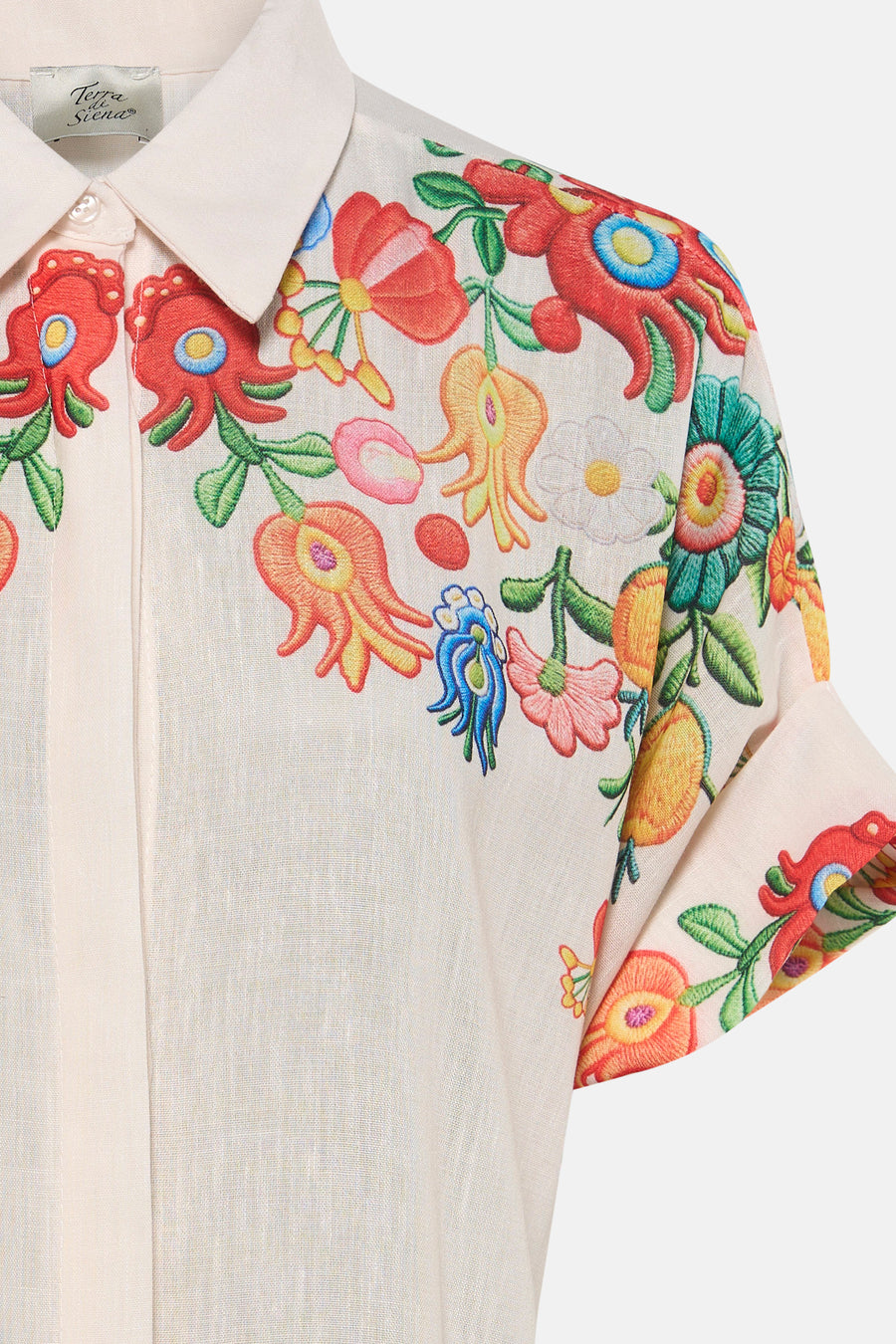 Chemise en lin beige clair à manches courtes de Terra di Siena, avec motif brodé coloré de fleurs et de formes organiques.