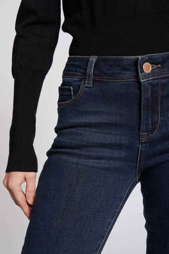 Blauwe skinny jeans van Morgan De Toi, met donkere wassing en bruine stiksels, gecombineerd met een zwarte trui.
