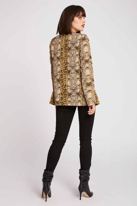 Blazer multicolore de Morgan De Toi, avec imprimé serpent et porté avec un pantalon noir et des bottes à talons.