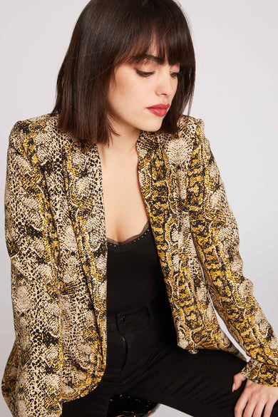 Blazer multicolore de Morgan De Toi, avec un imprimé serpent, porté sur une chemise noire avec des détails bordés.