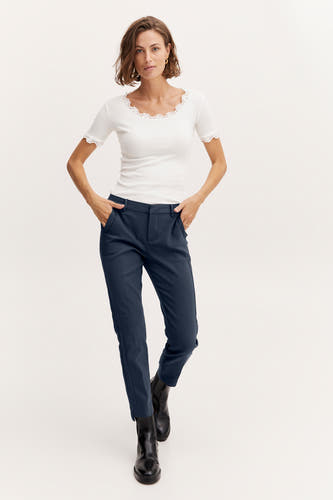 Chino bleu de France, associé à une chemise blanche à col blanc et des bottes noires.