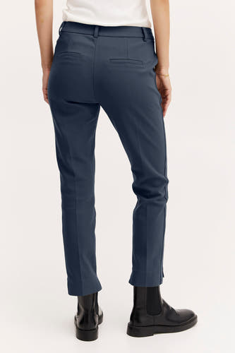 Jean bleu de France, vu de derrière, associé à des bottes en cuir noires.