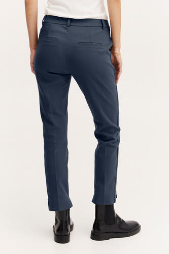 Jean bleu de France, vu de derrière, avec des poches et des bottes noires.