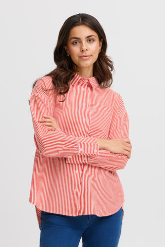 Chemise rayée rouge et blanche à manches longues de France, avec colletage et poche poitrine, portée avec des jeans bleus.