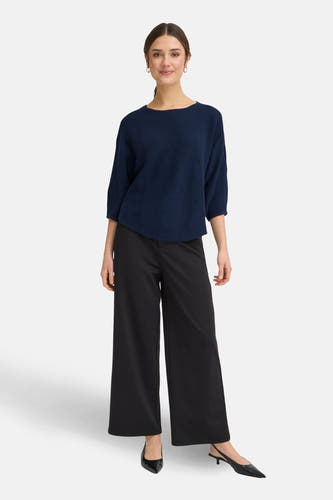 Blauwe trui met ronde hals van Fransa, gedragen met zwarte wijde pijpen broek en pumps.
