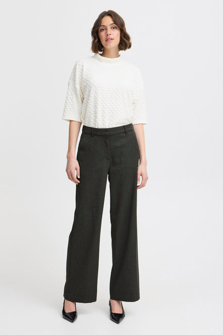 Pantalon gris de France, avec une largeur et porté avec un blanc blanc.