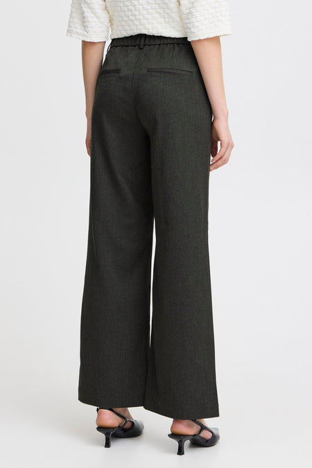 Grijze broek van Fransa, gezien van achteren met wijde pijpen en bijpassende zwarte pumps.
