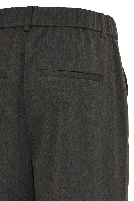 Pantalon gris de France, avec une poche passepoilée à l'arrière et une ceinture élastique.