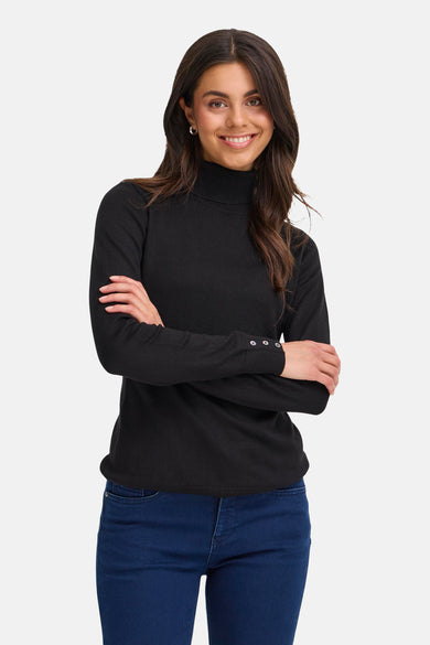 Gilet noir de France, avec longues manches et boutons décoratifs sur les manches, associé à un jeans bleu marine.