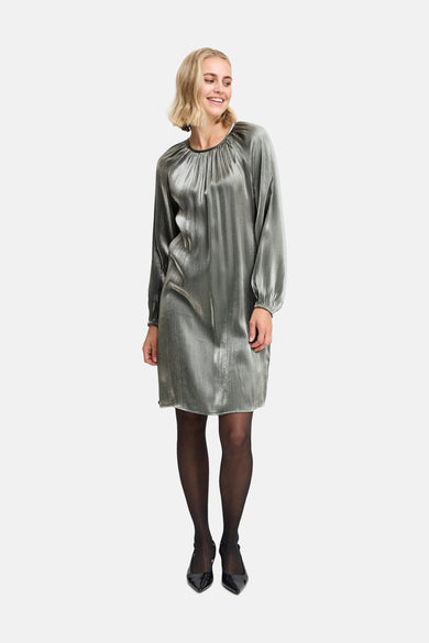 Robe d'argent avec des manches longues de France, portée avec un string noir et des escarpins.