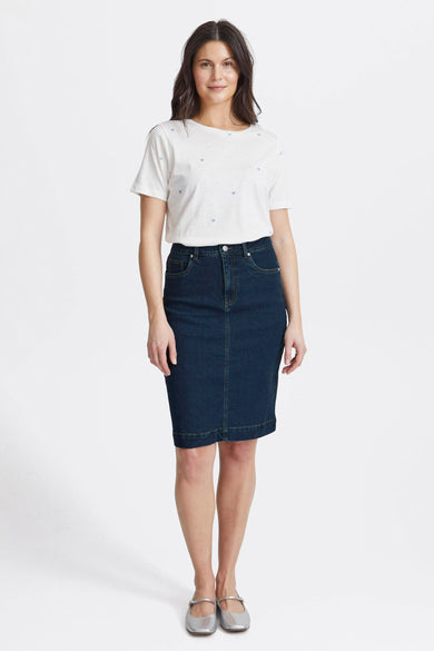 Jupe en denim bleu marine de France, avec une coupe ajustée, associée à un t-shirt blanc avec des cœurs.