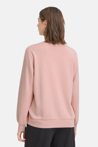 Roze sweater van Fransa, gezien van achteren, met lange mouwen en zwarte broek.
