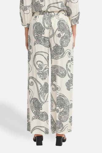 Pantalon écru de France, avec un imprimé paisley et une large ce.