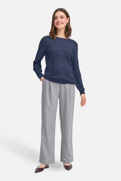 T-shirt bleu avec col rond de France, porté avec un pantalon gris et des chaussures marron.