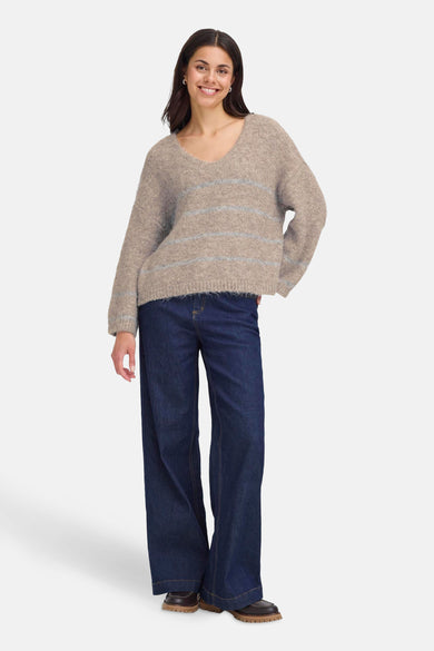 Gilet beige à col V de Fransa®, fini avec des fines rayures horizontales, associé à des jeans larges et des chaussures marron.