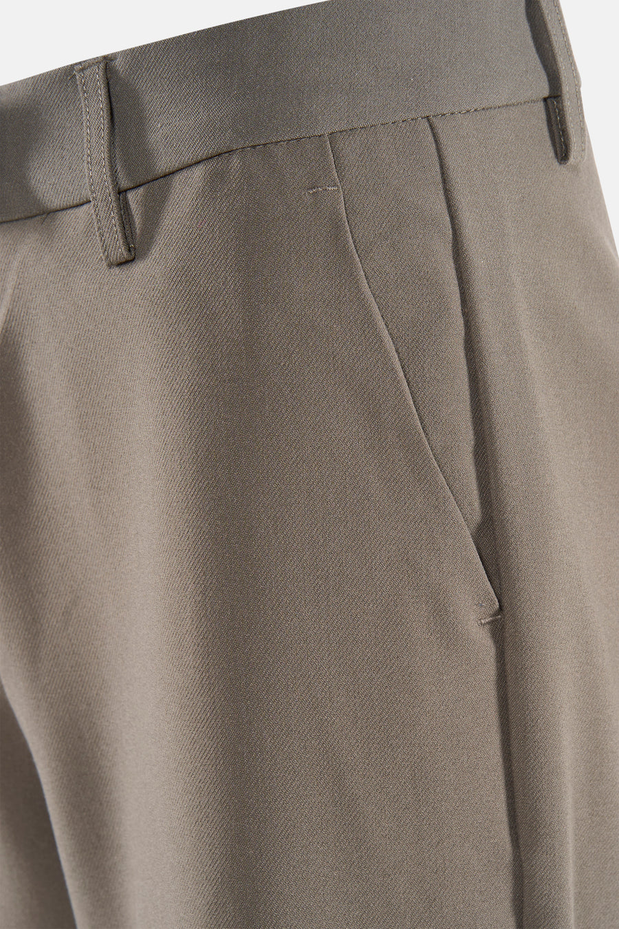 Pantalon brun de France, gros plan sur la ceinture et la poche, avec une subtile texture.