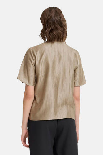 Blouse beige à manches courtes de Fransa, avec des plis subtils et portée avec une jupe noire, vue de derrière.