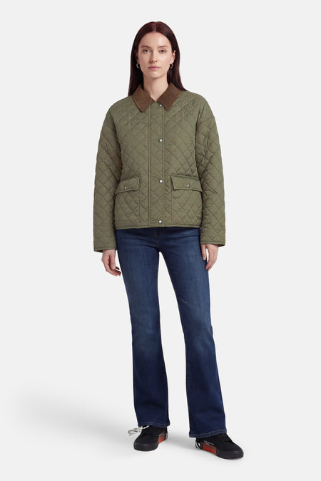 Manteau court kaki de Fransa avec col marron, combiné avec un jean foncé et des baskets noires.