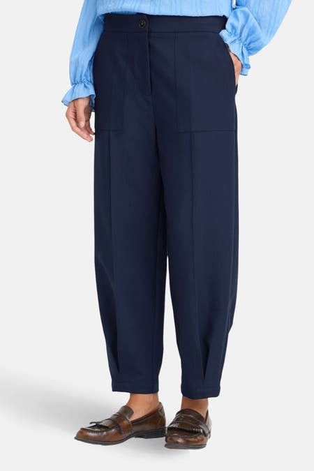 Pantalon bleu de France, avec deux poches arrière cousues et des chaussures marrons.