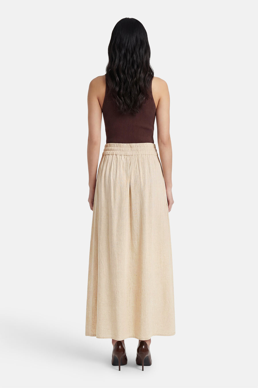 Jupe longue beige de Fransa, vue de dos, avec une taille élastique et des escarpins marron.