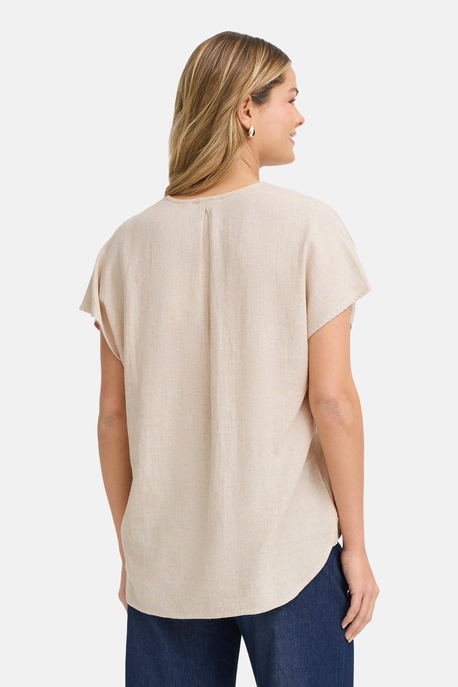 Chemisier beige à manches courtes de Fransa, avec des plis au dos et porté avec un pantalon foncé.