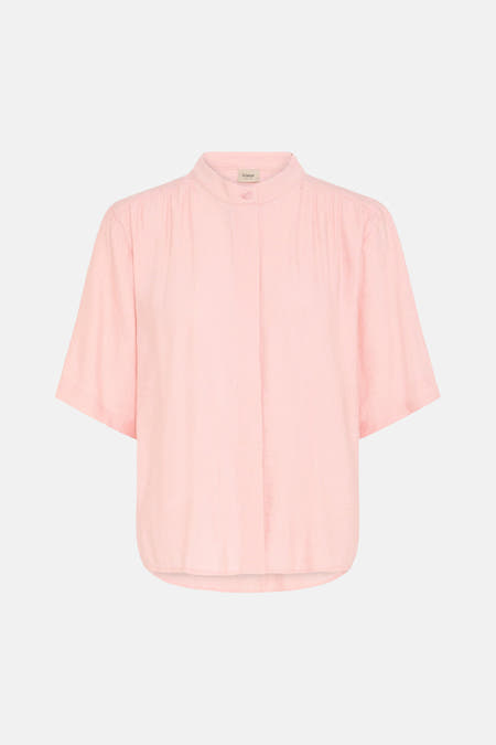 Chemise rose à manches courtes de Fransa® avec texture légère et col mao, portée par un mannequin avec un pantalon beige dans un cadre lifestyle.