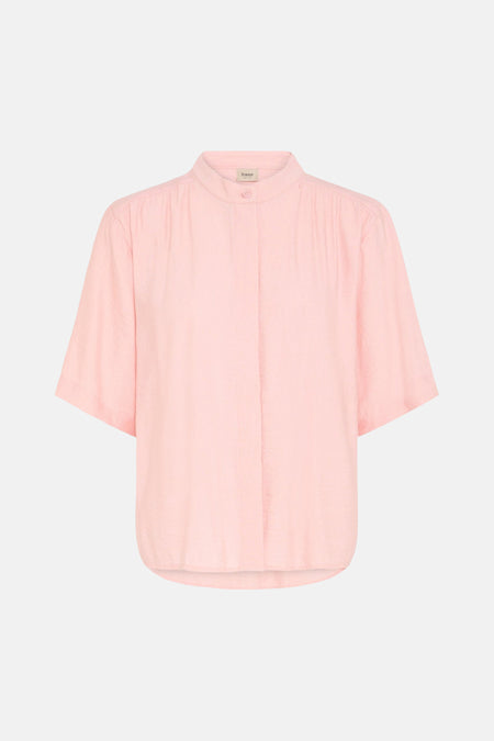 Chemise rose à manches courtes de Fransa® avec texture légère et col mao, portée par un mannequin avec un pantalon beige dans un cadre lifestyle.