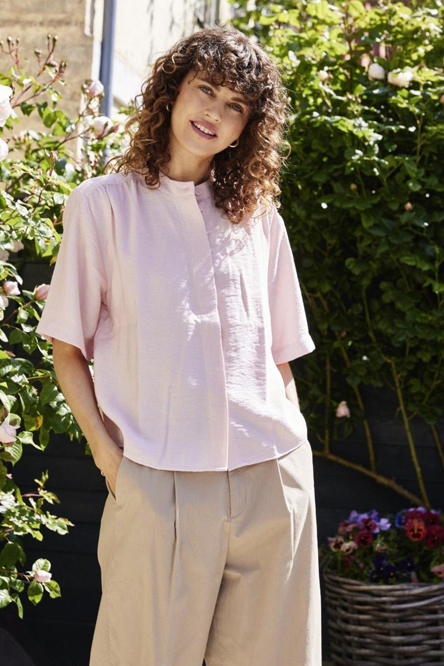 Roze hemd met korte mouwen van Fransa® met lichte textuur en bandkraag, gedragen door een model met beige pantalon in een lifestyle setting.