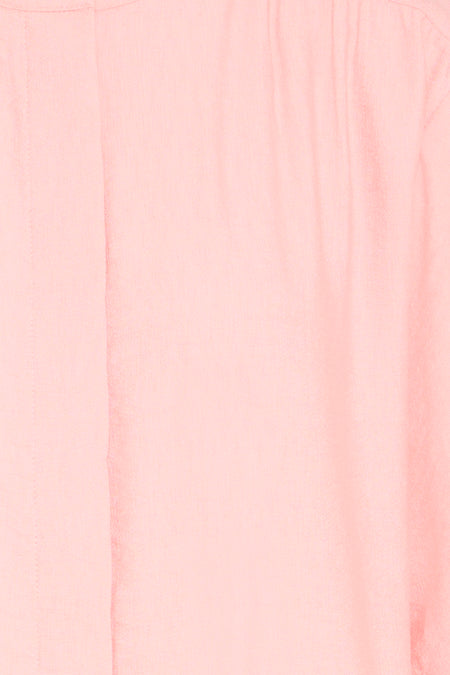 Chemise rose de Fransa avec un gros plan de la texture du tissu, des plis verticaux subtils et une ligne d'ourlet sur le côté gauche.