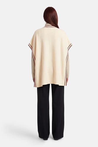 Gilet écru de Fransa, avec passepoil contrastant et combiné avec un pantalon noir et un pull beige.