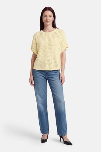 Gele pull met ronde hals van Fransa, met ajourpatroon, korte mouwen, gedragen met jeans en zwarte hakken.