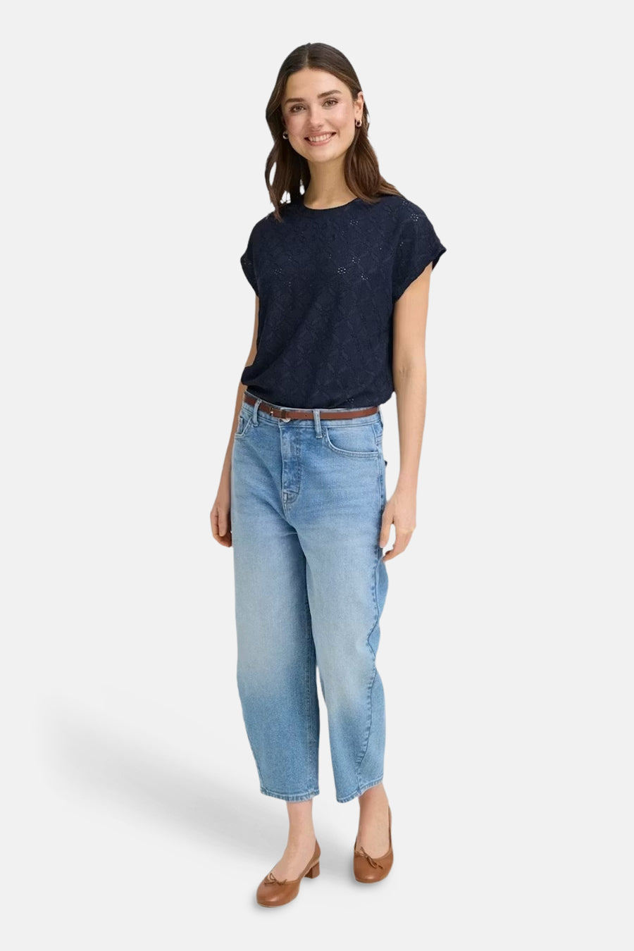 Blauw T-shirt met korte mouwen van Fransa, met een subtiel patroon. De vrouw draagt jeans met een bruine riem en schoenen.