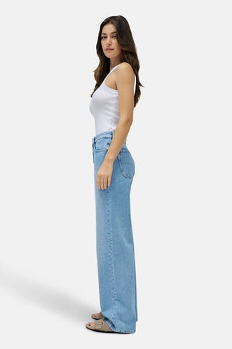 Jean décontracté de denim bleu clair de Salsa Jeans, vu de côté, avec un t-shirt blanc et des sandales.