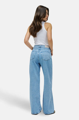 Jean large en denim bleu clair de Salsa Jeans, vu de de derrière, avec une chemise blanche.