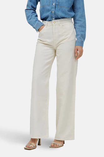 Jean denim off-white de Salsa Jeans, avec des jambes larges et des poches arrière, associés à un chemisier denim bleu.