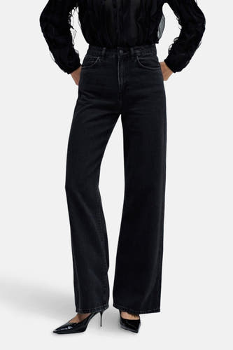 Jeanon de de large de Salsa Jeans, avec des jambes qui s'élargissent et porté avec une blouse noire et des escarpins.