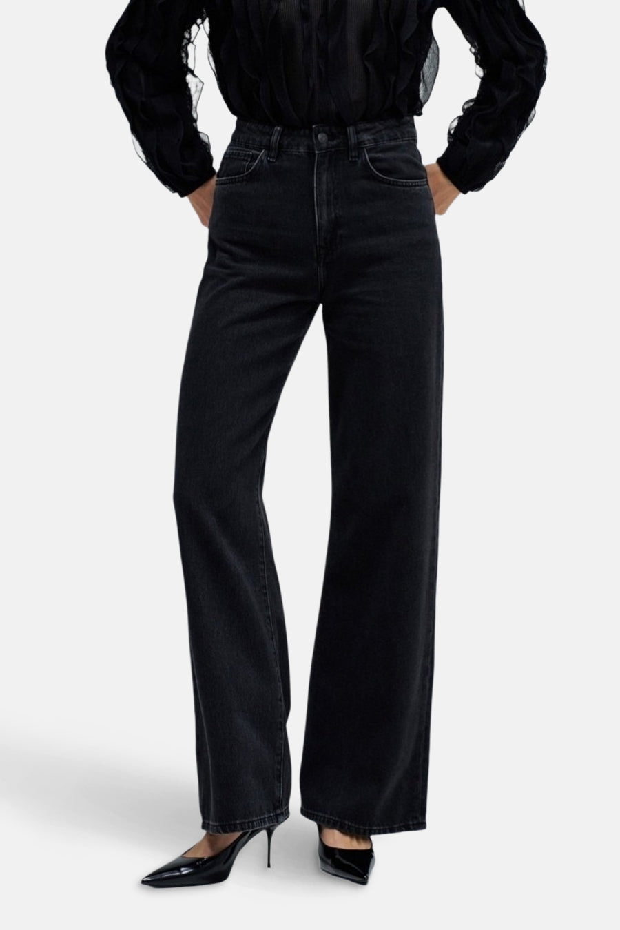 Jeanon de de large de Salsa Jeans, avec des jambes qui s'élargissent et porté avec une blouse noire et des escarpins.