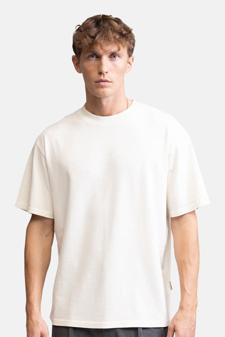 Ecru T-shirt met korte mouwen van REDEFINED REBEL, gedragen met gouden ketting.