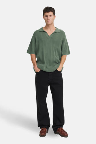 Groene trui van SOLID, met korte mouwen en een V-hals, gedragen met zwarte broek en bruine schoenen.