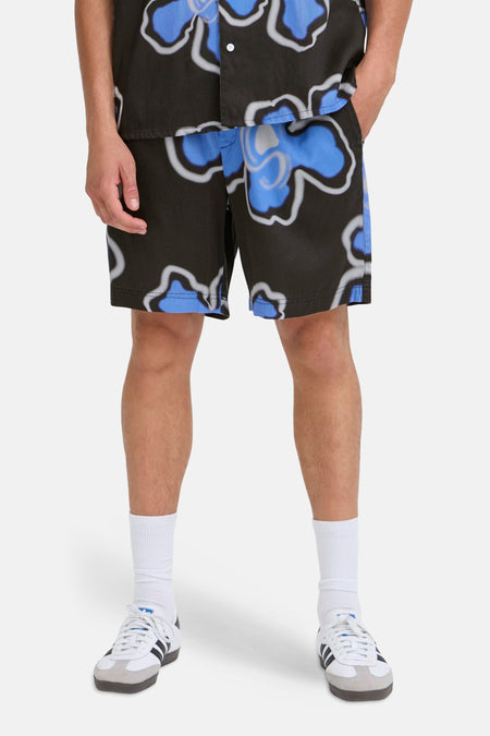 Short multicolore de SOLID avec un motif floral, porté avec des chaussettes blanches et des baskets.