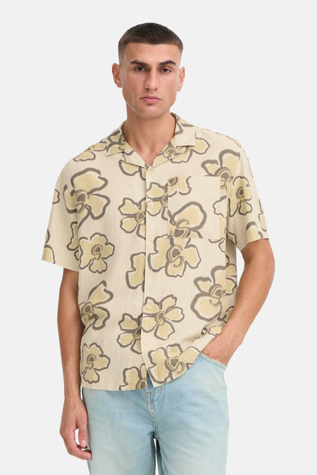 Chemise beige à manches courtes de SOLID, à motif floral et portée avec un jean bleu.
