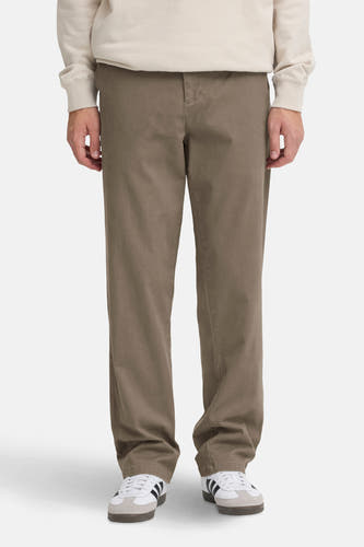Jean chino marron de SOLID, porté avec un pull beige et des baskets blanches à rayures noires.